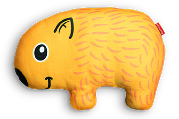 Orange wombat shaped cushion with black eyes and nose, and a red tag on its side