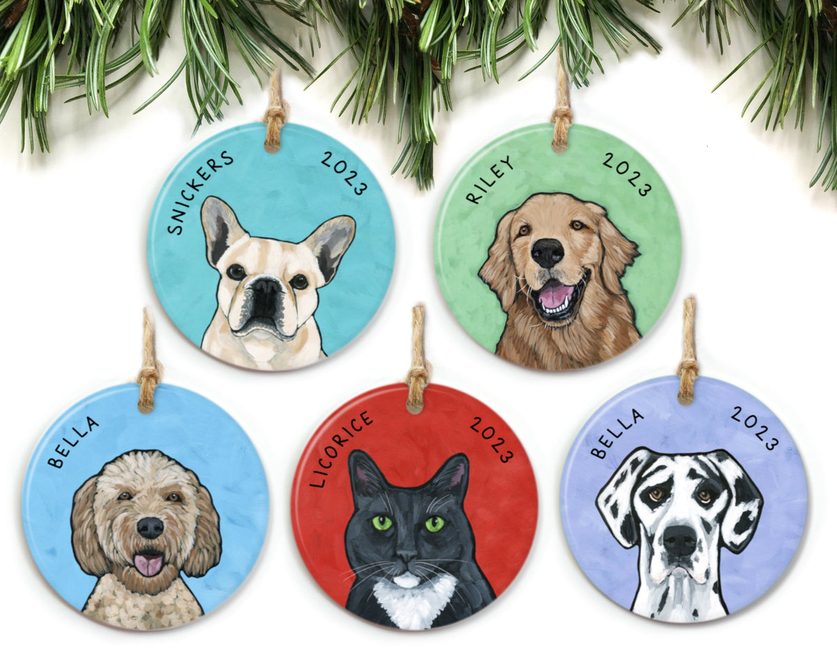 Five pet ornaments hanging from pine needles. Each ornament features a different pet portrait.