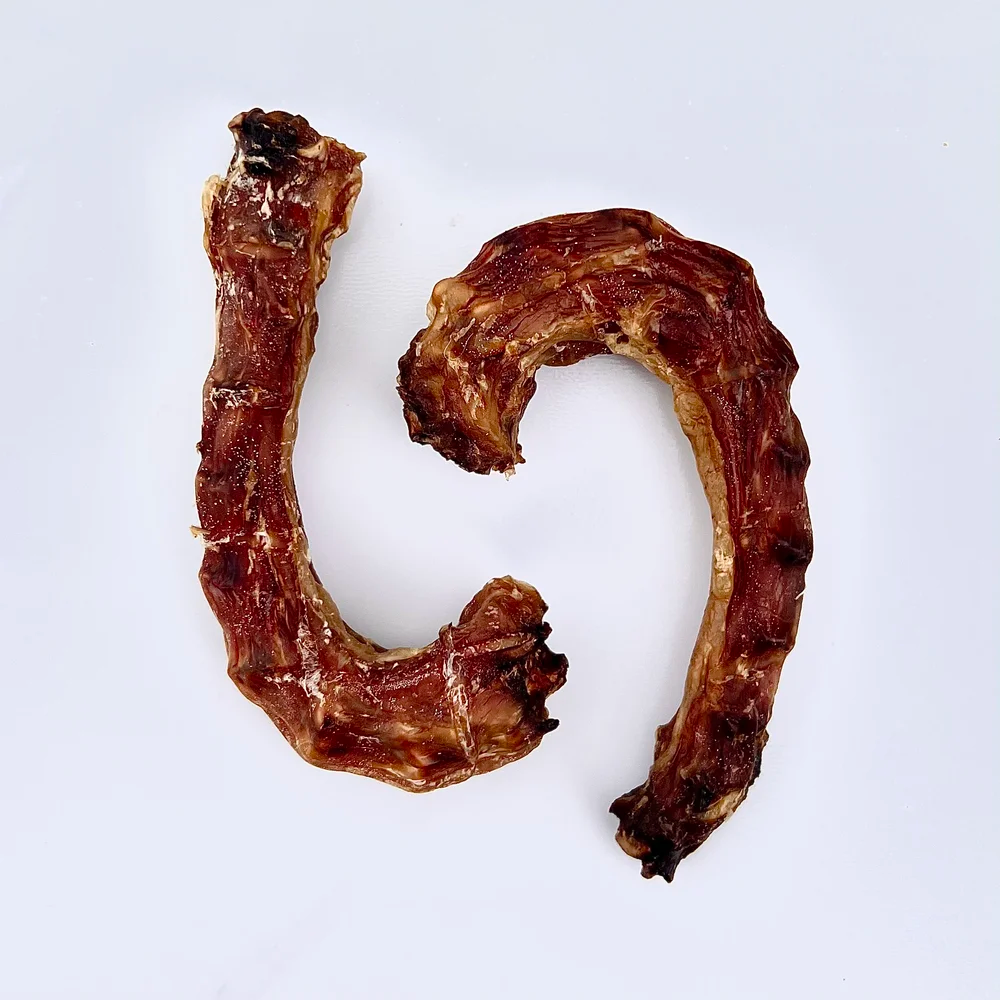 Two dehydrated chicken necks on a white background