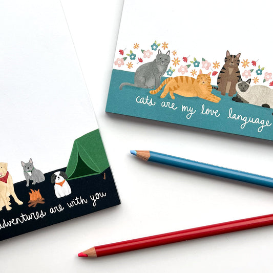 The Cheery Pet Cat Notepad with four illustrated cats and floral border, and two colored pencils