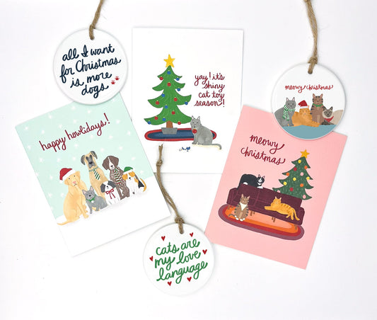 Five holiday cards and three ornaments featuring dogs and cats