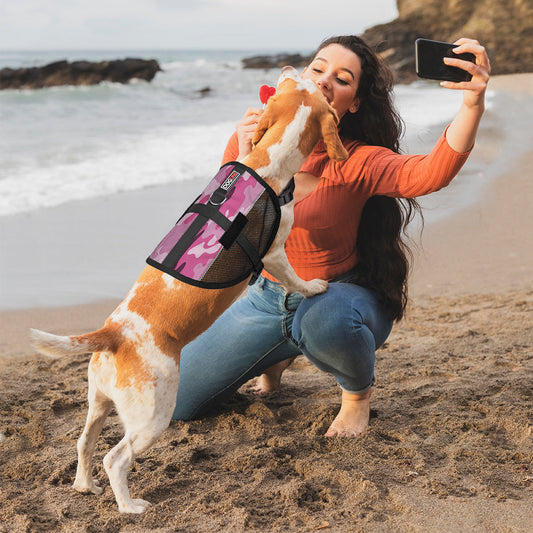 Woman taking a selfie with a dog wearing a DOGLINE MaxAire Mesh Vest in pink camouflage on the beach