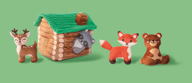 Plush deer, raccoon, fox, and bear toys with a plush log cabin