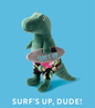 Green dinosaur plush toy wearing floral swim trunks and holding a grey surfboard that says SURF'S UP