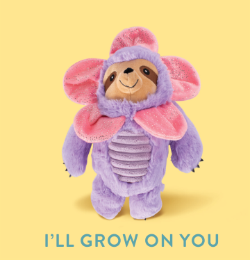 Purple sloth plush toy with pink flower petals around its head and a textured belly