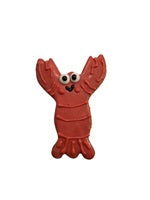 Red lobster shaped cookie with googly eyes and a smile