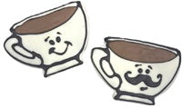 Paws Gourmet Bakery Puppachino cookies shaped like coffee cups, one with a smile, one with a mustache