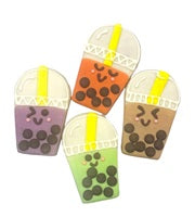 Four bubble tea shaped cookies with different colored frosting and smiling faces