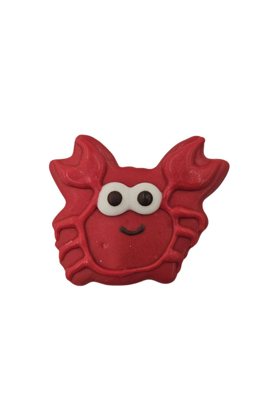Red crab shaped cookie with white and black eyes and a small black smile